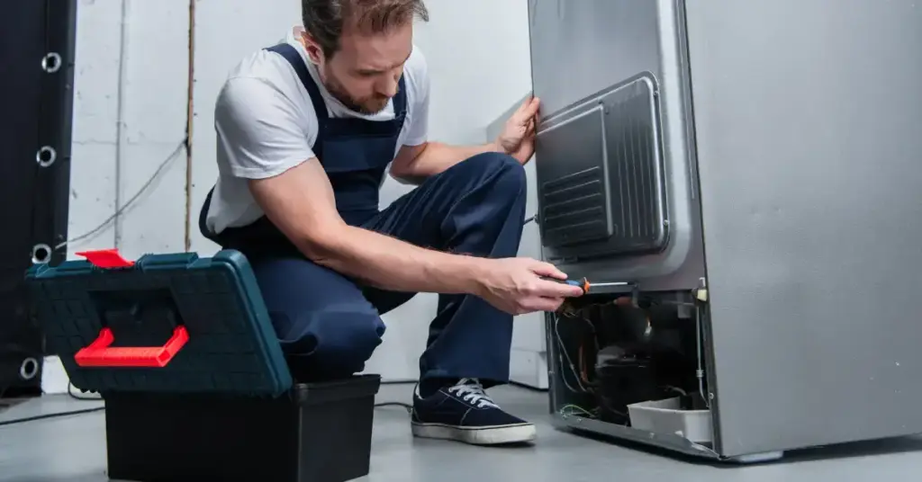 Técnico fazendo o conserto de geladeira